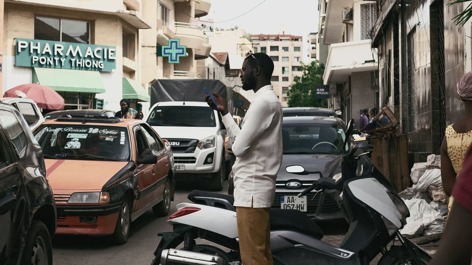 Une rue commerçante africaine, devantures et circulation.